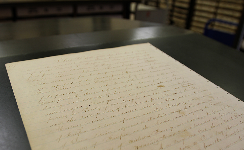 Photograph of the deed for the Dranesville school property on a table in the Circuit Court Historic Records Center.